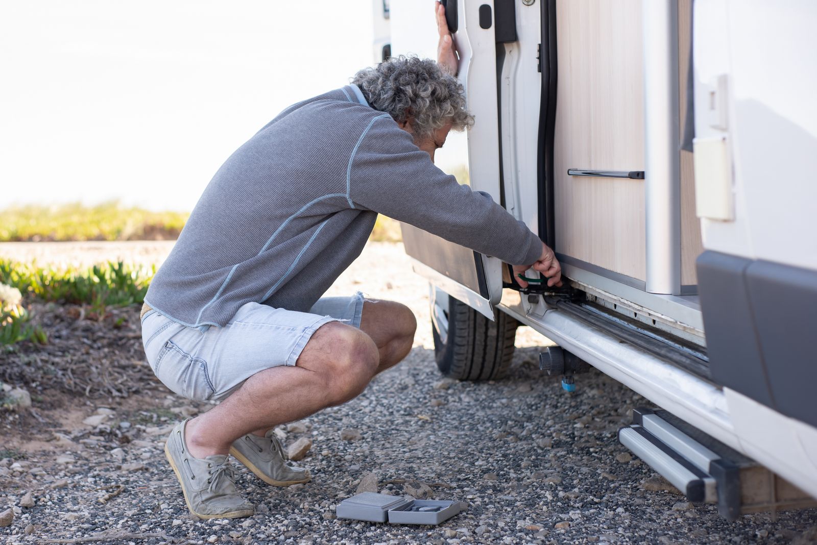 A technician inspecting and repairing an RV