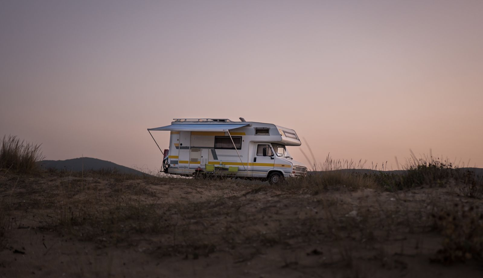 An RV on the open road at sunset