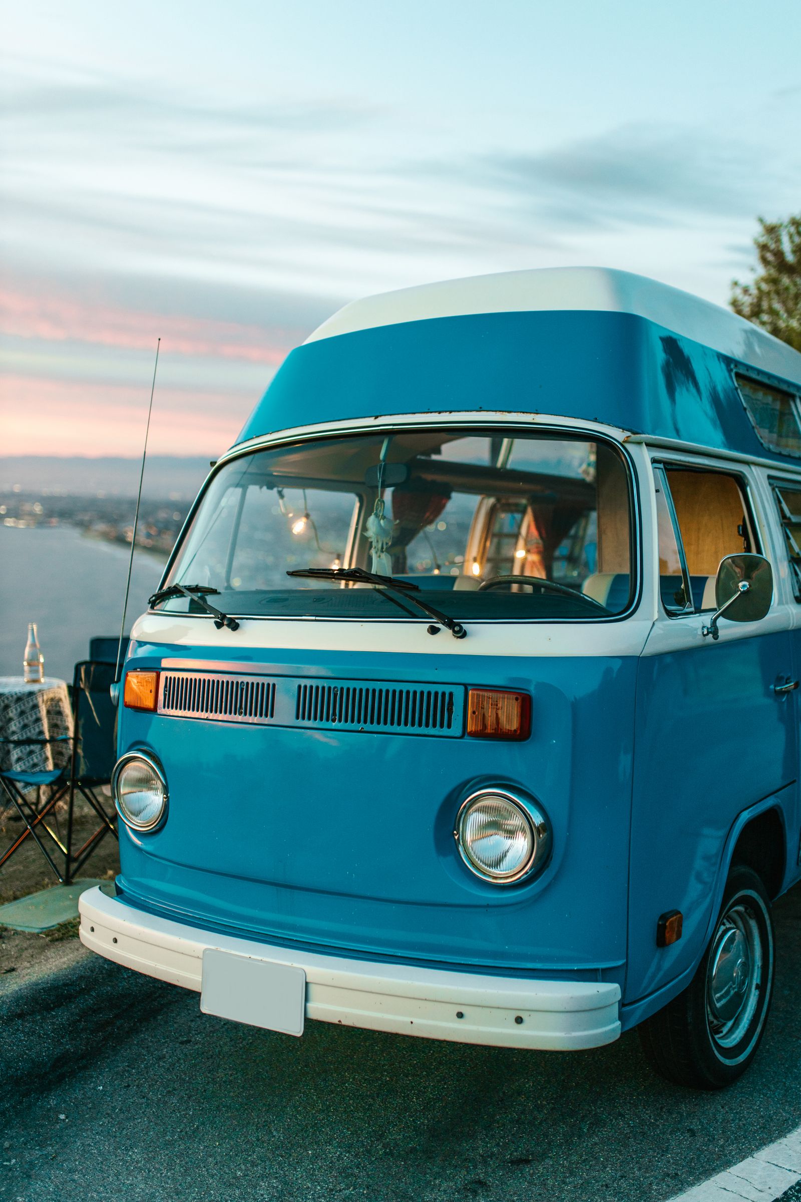 A camper van parked at a scenic coast at sunset